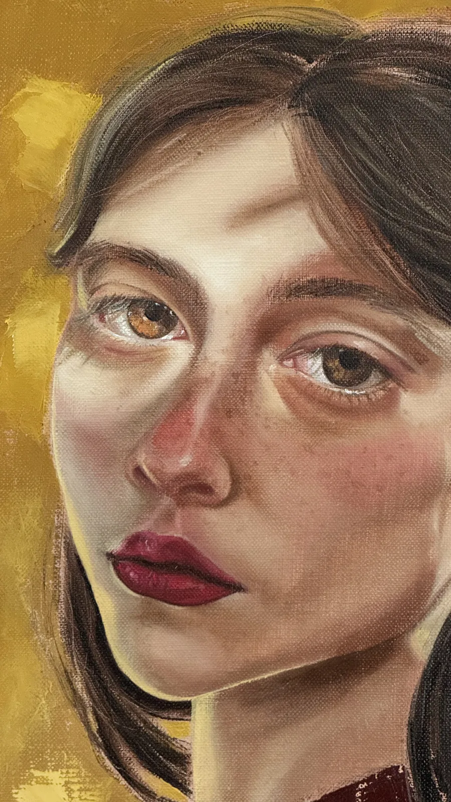 Close-up of the face: amber eyes, freckles and dark red lips