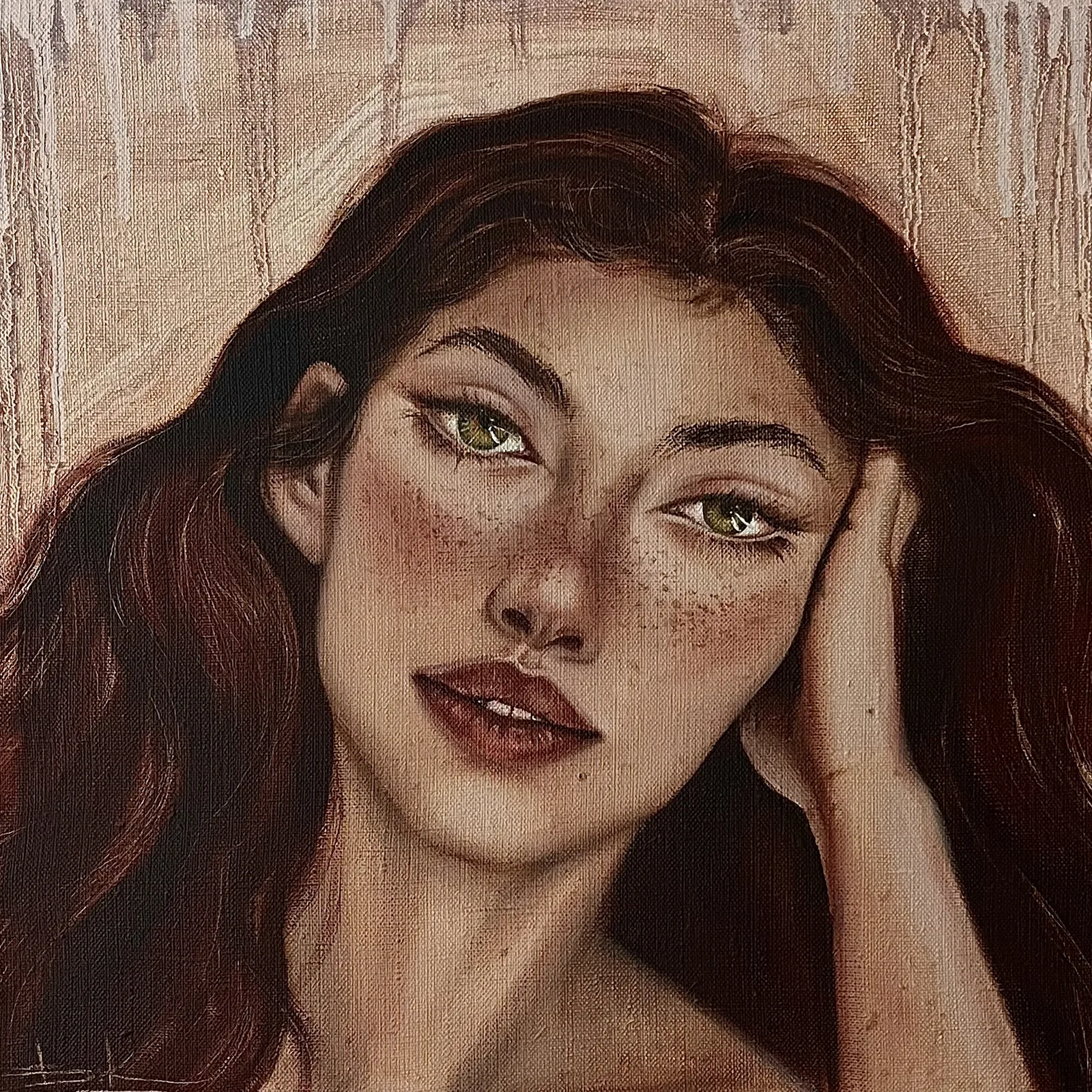 Woman with dark auburn hair resting her cheek on her hand against a warm pale ground
