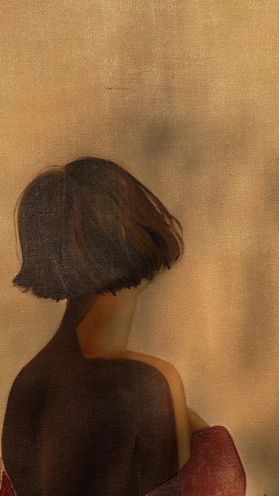 Detail: the bob haircut and bare shoulders against the lit wall