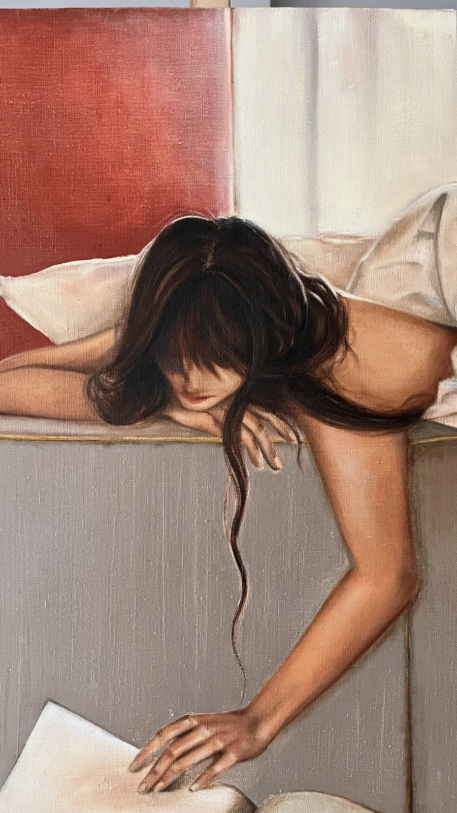 Detail: her hand reaching down to an open book