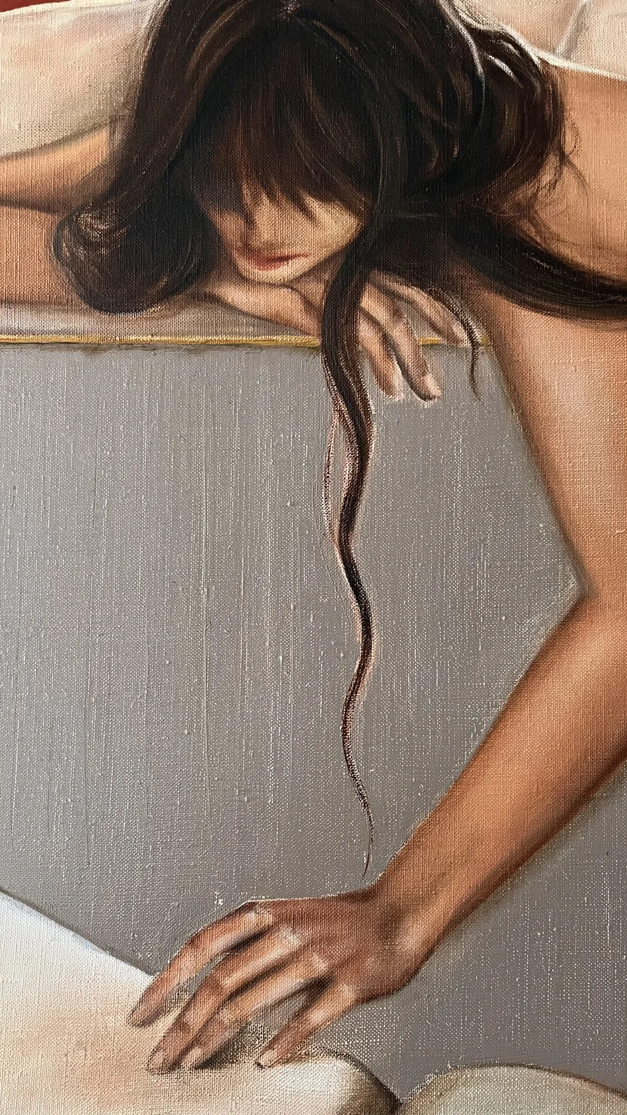 Detail: strands of hair and fingers against the grey sofa