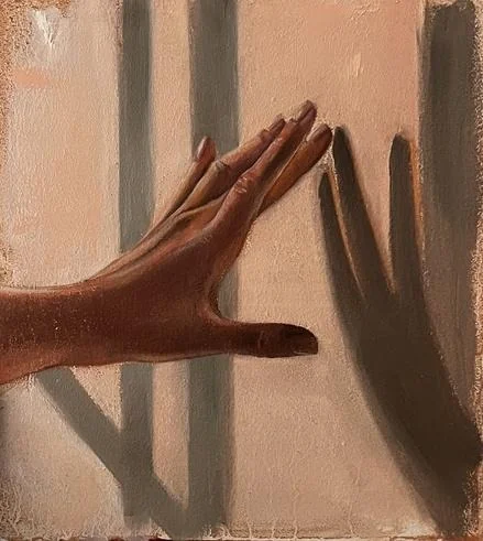 A hand pressed against a sunlit wall, its shadow falling beside it